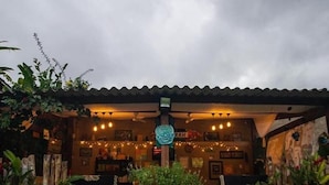 Cómoda zona de estar al aire libre con barra, rodeada de exuberante follaje y plantas en macetas.