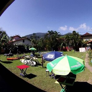Een gazon met fiets, rode stoel en diverse parasols.