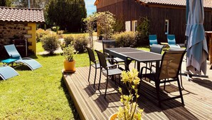 A wooden deck with outdoor furniture, a table, and chairs.