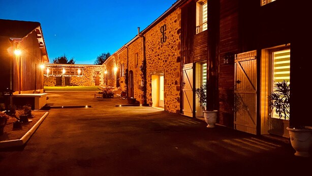 A stone building with a large garage door and a well-lit entrance.