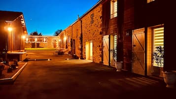 Un bâtiment en pierre doté d’un grand portail de garage et d’une entrée bien éclairée.