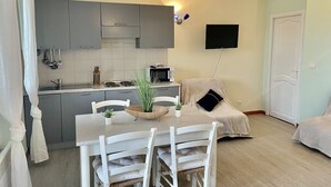 A compact living space with a kitchenette, a dining area, and a bed. - Apartment 6 pers 3 mn from the beach sea view (FAVONE)