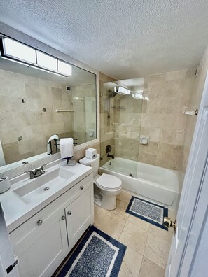 A bathroom with a sink, toilet, and bathtub.