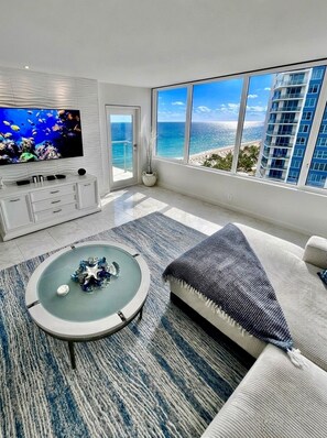 A modern living room with a large TV, a round coffee table, and a sofa.