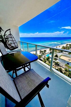 A balcony with a view of the beach and ocean.