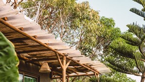 A wooden deck with lush greenery and a pergola structure.