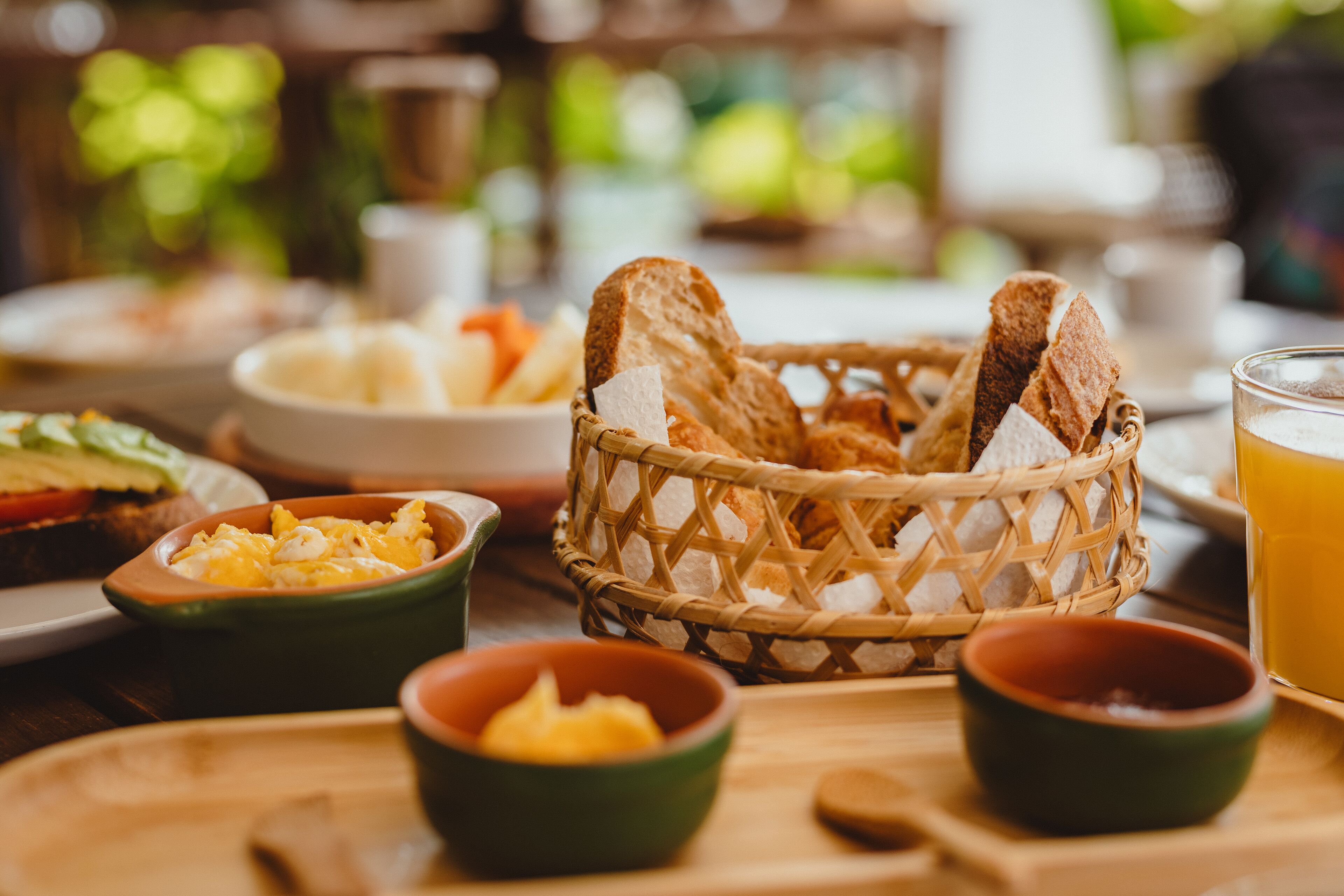 A breakfast setting with bread, eggs, and juice.