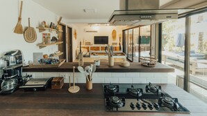 A modern kitchen with a gas stove, coffee maker, and various kitchen utensils.