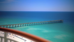 A pier extending into a clear blue sea with a beach in the foreground. - Beach Colony West 12A Gulf-Front 3 BD/3BA w/Beach Service & Onsite Management (Navarre Beach)