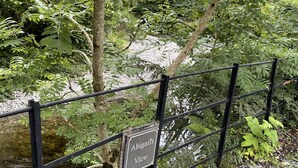 A sign reading "Abigail's View" on a metal fence in a lush, green area with trees and a stream. - Newly refurbished 2 bedroom, 2 bathroom apartment right in the heart of Grasmere (Grasmere)