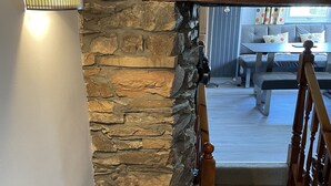 A staircase with a stone wall on one side and a wooden railing. - Newly refurbished 2 bedroom, 2 bathroom apartment right in the heart of Grasmere (Grasmere)