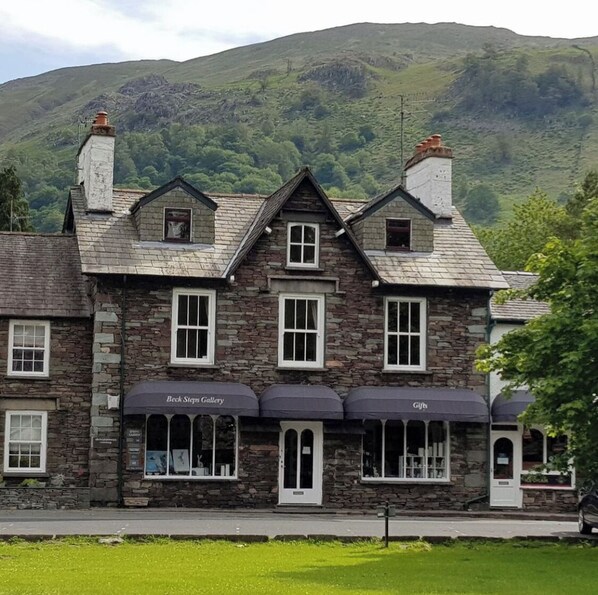 A stone building with a gallery on the ground floor and a gift shop on the upper level.