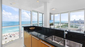 A modern kitchen with large windows offering a view of the beach and ocean. - Oceanfront Private Condo at The Setai -2208 (Miami Beach)