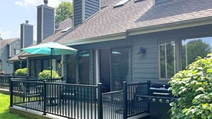Une maison dotée d’un patio couvert, de mobilier d’extérieur et d’un barbecue.