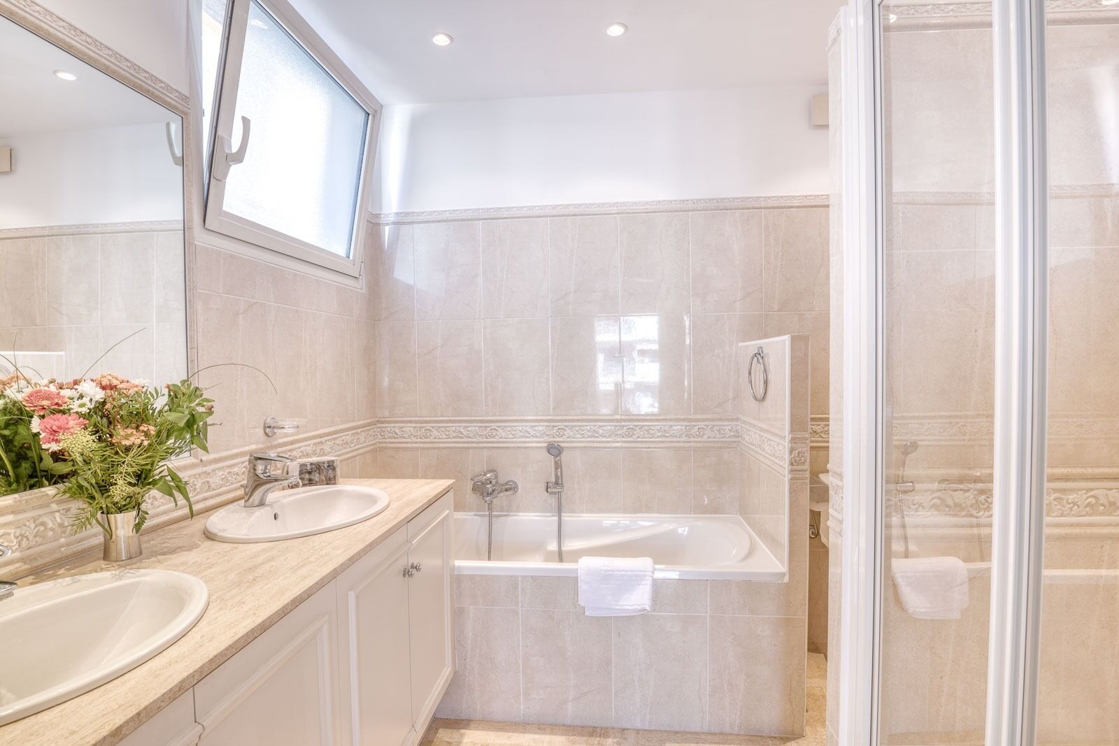 A bathroom with two sinks, a bathtub, and a shower.