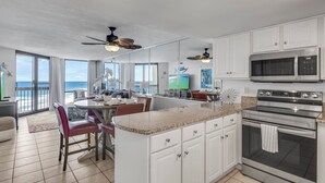 A modern kitchen with white cabinets, a microwave, an oven, and a large island with seating. - Spectacular views of the Gulf and Emerald coast - 16th floor. (Destin)