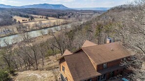 A wooden cabin with a sloped roof, surrounded by a forested area and a river in the background. - Riverfront Oasis with Mountain Views, close to town  (Middletown)
