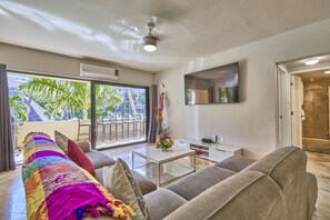 A modern living room with a sofa, a coffee table, and a TV.