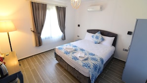 Habitació d'hotel amb un llit, una làmpada, una finestra amb cortines i una làmpada al sostre.