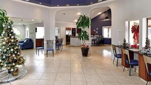 A spacious lobby with a Christmas tree, a large potted plant, and a bar area. - Shorewalk "A Little Piece of Paradise" close to beaches, golf, restaurants, IMG (Bradenton)