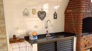 Una cocina con horno de ladrillo, un lavabo y adornos en la pared.