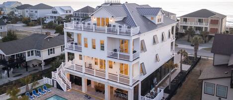 A multi-story residential building with a pool, balconies, and a view of the ocean.