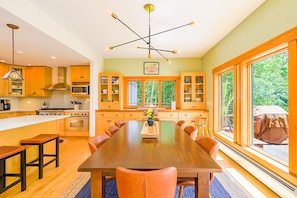 Una cocina amplia con una isla central, armarios de madera y ventanas grandes que ofrecen vistas al exterior.