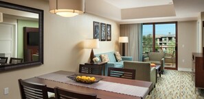 Relax in this inviting space with a dining area, comfortable sofa, and large window offering a view of the surrounding cityscape.