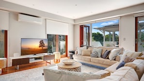 Relax in this stylish living room with a flat-screen TV, comfortable sofa, and a coffee table.