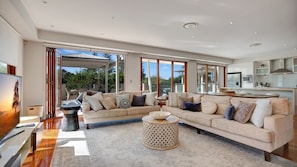 Relax in this inviting living area with a large sofa and coffee table, offering a view of the outdoors.