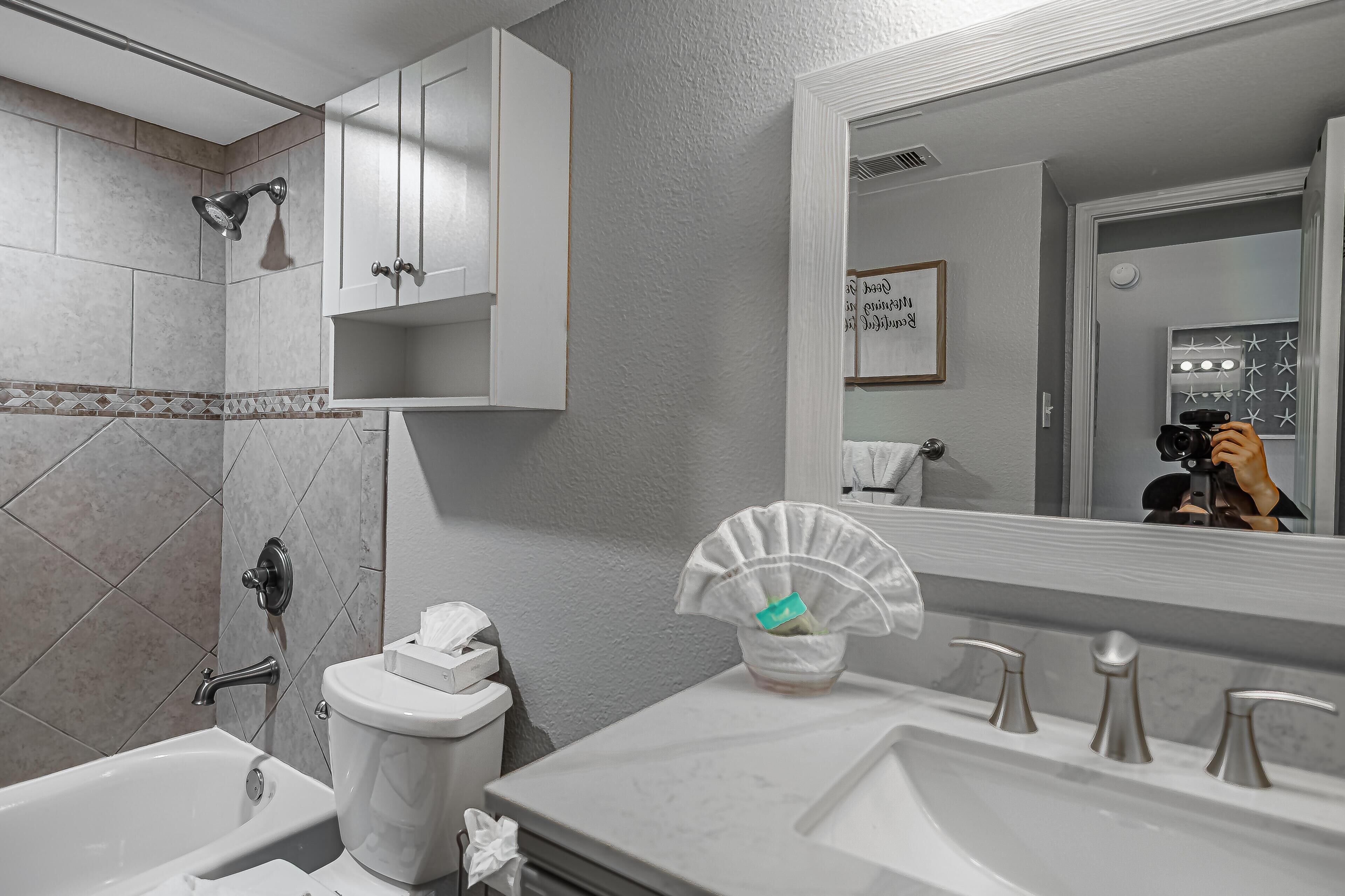 Een moderne badkamer met een bad, toilet en wastafel.