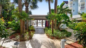 A pathway leading to a covered area with palm trees and a Coca-Cola sign. - Seascape 1120 in Galveston (Galveston)
