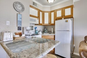Kitchen features a microwave, stainless steel sink, and refrigerator.