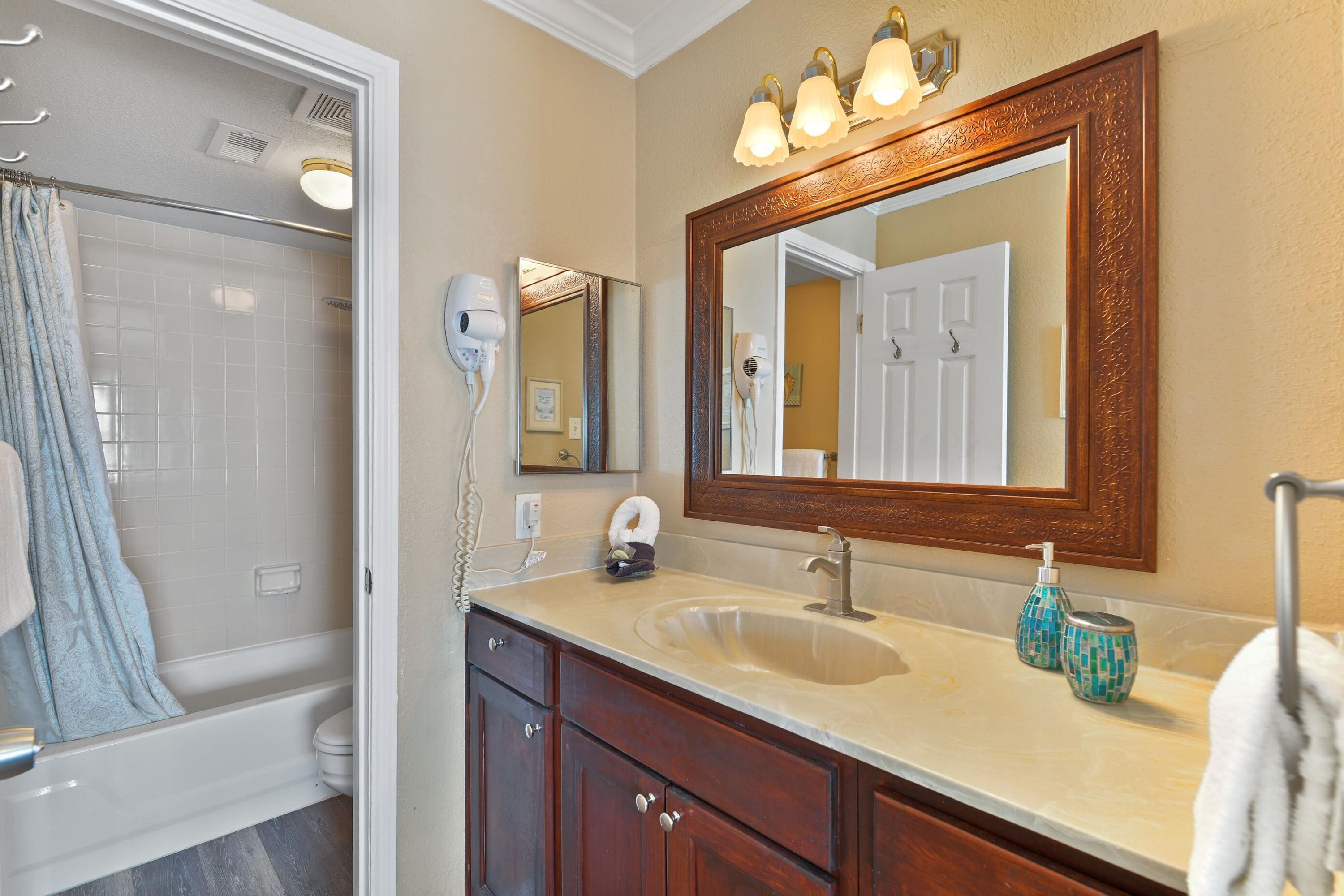 A bathroom with a bathtub, a sink, a mirror, and a shower.