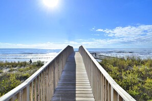 Walk along the boardwalk to the ocean, flanked by lush vegetation.
