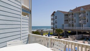 Un balcone con vista sull'oceano e un edificio con diversi balconi e una terrazza coperta.