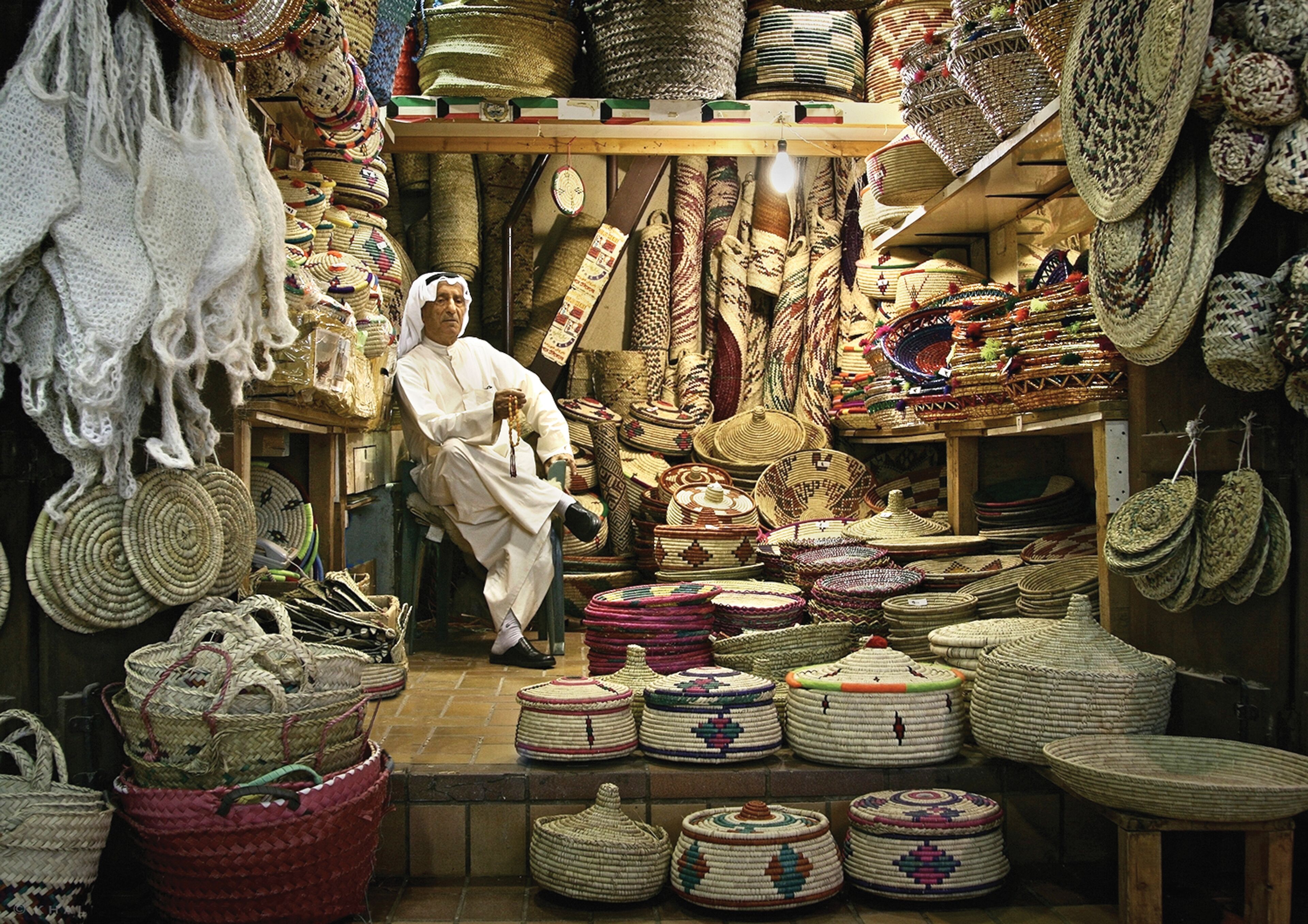 Un puesto de mercado con varias cestas tejidas y textiles.