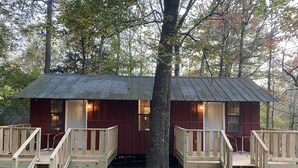 Two wooden cabins with external staircases, surrounded by trees. - Yeti Cabin (Benton)