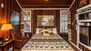 A room with a bed, a chair, a lamp, and a painting on the wall. - Yeti Cabin (Benton)