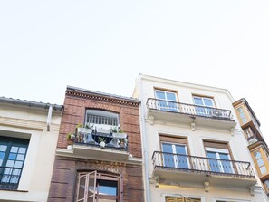 A multi-story building with balconies, large windows, and a brick facade. - Del Parque Flats Especerias Balcony (Malaga)