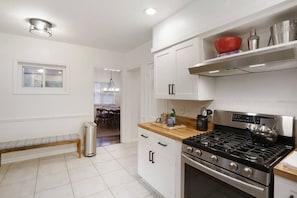 A modern kitchen with white cabinetry, a gas stove, and a built-in oven.