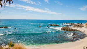 A beach with clear blue water, rocky outcrops, and a sandy shore. - COZY, OCEAN VIEW CONDO WITH PRIVATE BEACH ACCESS (CABO SAN LUCAS)