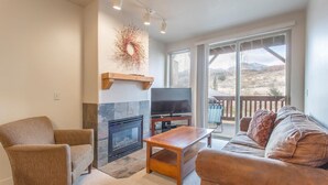 A living room with a fireplace, a television, and a sofa. - Cozy 2BD/2BA Mountain View Condo, near skiing, Sleeps 4+ (Park City)