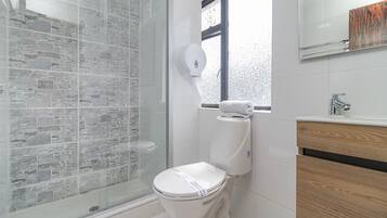 Habitación estándar doble | Baño | Ducha, artículos de higiene personal de diseño, toallas y jabón