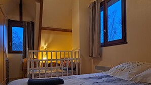 Ein gemütliches Zimmer mit einem Bett, einem kleinen Tisch und einem Fenster mit Vorhängen.