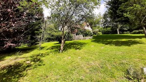 Ein gepflegter Garten mit verschiedenen Bäumen und einer Steinmauer.