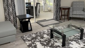 Ein modernes Wohnzimmer mit einem Glastisch, einem grauen Sofa und einem gemusterten Teppich.