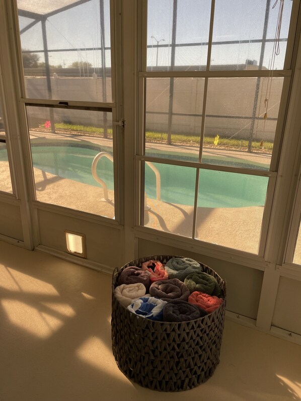 Enjoy a view of the outdoor pool from the large window, which is framed with white trim.