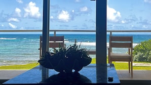 A balcony with a view of the ocean, two wooden chairs, and a potted plant. - SUITE 167m2, facing the beach, sleeps 8, DBC, sharing JW Marriot facilities. (Oyster pond)