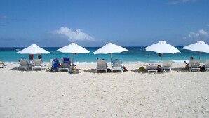 A beach with white umbrellas and lounge chairs. - SUITE 167m2, facing the beach, sleeps 8, DBC, sharing JW Marriot facilities. (Oyster pond)